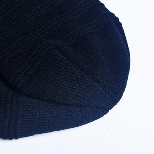 Close-up of premium thick knitted texture and warm fabric detail on a black beanie