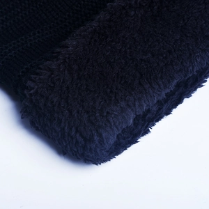 Detail of black knit beanie featuring thick thermal fleece lining for winter warmth