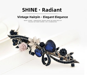 Macro shot of silver hair clip with blue crystal petals and pink resin flower detail