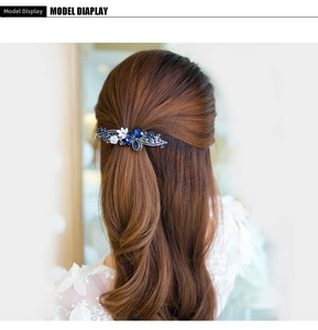 Elegant floral spring hair clip with blue rhinestones and white enamel flowers on hair