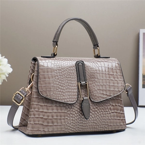 Elegant crocodile embossed top-handle handbag in taupe with gold buckle and adjustable strap