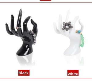Detail of hand-shaped resin jewelry stands in black and white for rings and bracelets
