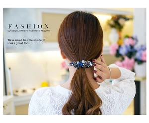 Detail of vintage blue crystal spring hair clip worn on a low ponytail hairstyle