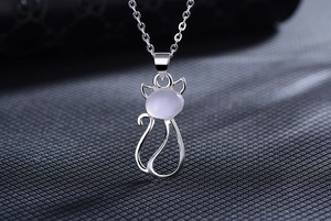 Macro shot of silver cat pendant necklace featuring a translucent oval stone inlay