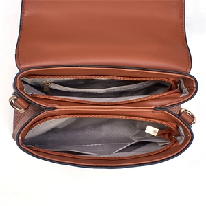 Detail of interior dual zipper compartments with herringbone lining and golden hardware