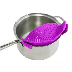 Close-up of purple silicone clip-on pot strainer attached to a stainless steel saucepan