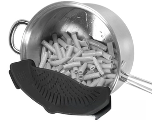 Close-up of black silicone clip-on strainer draining pasta from a stainless steel pot