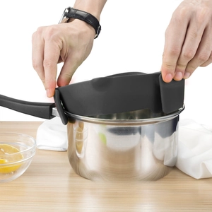 Macro view of flexible black silicone clip-on pot strainer being attached to a pan rim