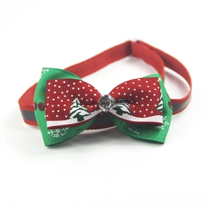 Close-up of a Christmas pet bow collar with red and green snowflake patterns and a rhinestone
