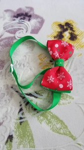 Detail showing the red Christmas bow tie collar with snowflake patterns and adjustable strap