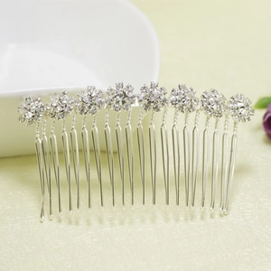 Gros plan d'un peigne à cheveux de mariée argenté avec huit motifs de fleurs en strass