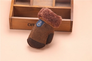 Detail of brown thick knitted mitten with plush cuff and blue garment label for kids