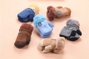 Detail view of colorful knitted baby mittens with plush cuffs in various striped patterns