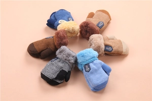 Flat lay of colorful thick knitted winter gloves for kids with cozy plush cuffs and tags
