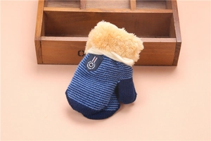 Detail of blue knit toddler glove with beige plush cuff and leather patch on wood tray