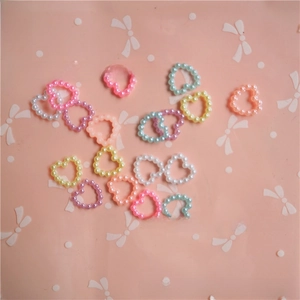 Flat lay of heart-shaped pearl bead accessories in pastel colors for DIY jewelry making
