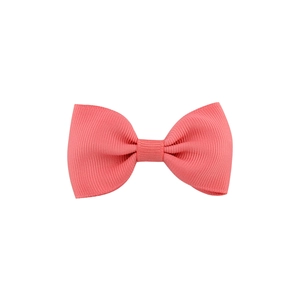 Detail of coral pink grosgrain ribbon bow hair clip with textured fabric finish