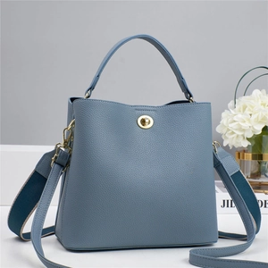 Detail of grey blue pebble leather bucket bag with gold hardware and two strap options