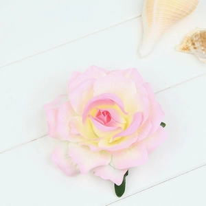 Detailed macro view of pink and yellow gradient artificial rose hair clip petal texture