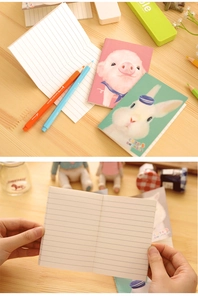 Nahaufnahme süßer Comic-Notizbücher mit Schwein- und Hasen-Motiven und linierten Innenseiten