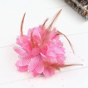 Close-up of pink feather hair clip with mesh petals and small pearls for dance performances