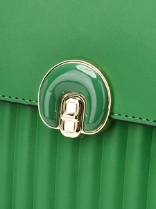 Detailed close-up of green leather bag featuring vertical pleated texture and gold clasp