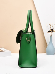 Detail view of emerald green tote bag side with PU leather texture and gold hardware