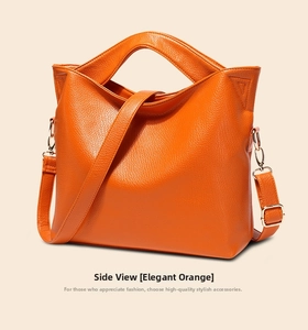 Close-up of orange litchi texture leather handbag with adjustable strap and metal hardware