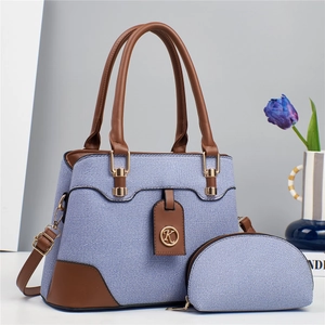 Blue denim crossbody bag set with brown leather handles and golden metal logo