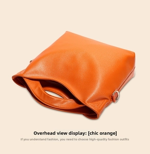 Detailed top view of orange lychee grain leather tote bag with gold D-ring hardware