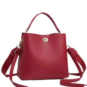 Classic red lychee leather bucket bag with top handle and gold turn-lock closure
