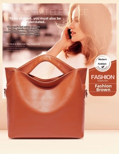 Detail view of the brown lychee grain leather tote bag featuring a unique geometric hollow handle