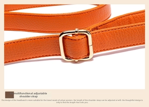 Detail of adjustable orange lychee grain leather shoulder strap with gold-tone buckle