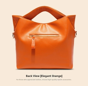 Rear view of orange lychee grain leather handbag featuring metal zip pocket and cat ear handles