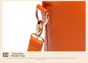 Detail of orange lychee leather handbag featuring detachable golden lobster clasp hardware