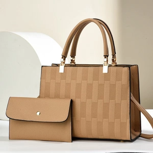 Khaki pebbled leather handbag set with checkered texture and gold hardware on white pedestal