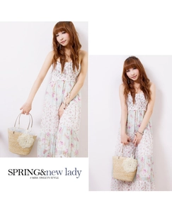 Detail of floral maxi dress paired with a woven straw handbag featuring lace flower decor