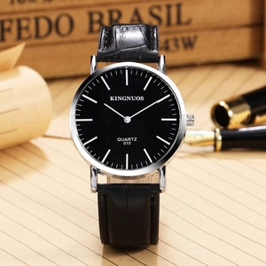 Classic men's business quartz watch with black dial and leather strap on a wooden desk