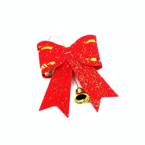 Reverse side detail of a double-layered red Christmas bow with gold glitter and bell