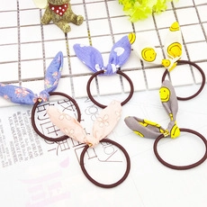 Dettaglio di quattro elastici per capelli a orecchie di coniglio con fiori e smiley