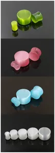 Detail showing colorful cat eye stone ear plugs in various sizes on black mirror base