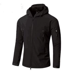 Close-up of tactical black functional jacket featuring multiple zipper pockets and hood