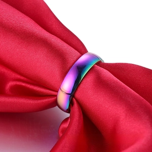 Macro view of rainbow stainless steel ring on red satin ribbon with smooth finish