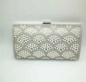 Detailed view of silver evening clutch with pearl and rhinestone mermaid scale pattern