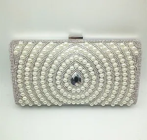 Detailed macro view of silver evening clutch bag featuring white pearls and rhinestones