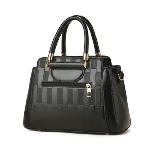 Detail view of black PU leather handbag with geometric lattice texture and gold hardware