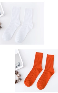 Detailed view of white and orange cotton crew socks with professional ribbed texture