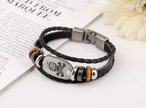 Detail of double-layer woven leather bracelet with skull plate and mixed beads