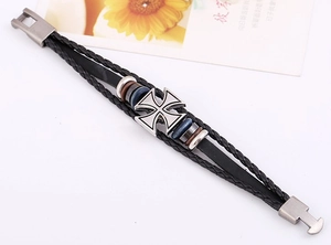 Macro view of multi-layer leather bracelet with metal iron cross pendant and bead accents