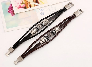 Detail view of woven leather bracelets featuring vintage silver cross metal ornaments